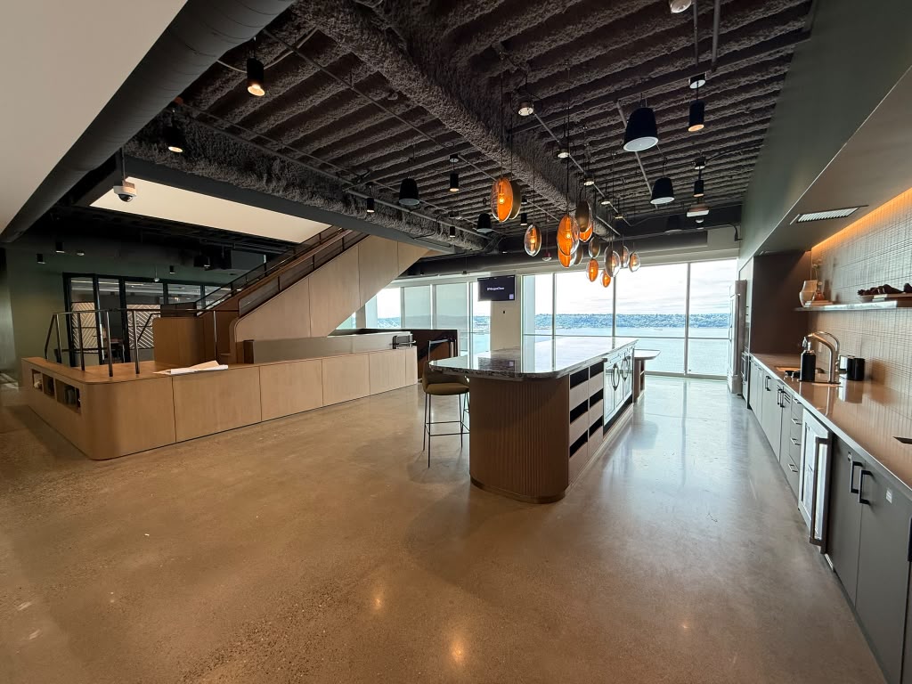 Corporate hospitality pantry with a bar island, pendant lighting and wall mounted signage overlooking the water