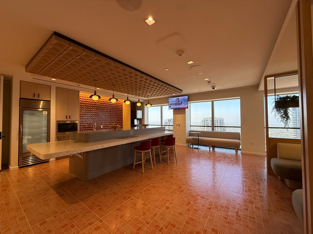 Executive lounge and pantry with a long counter, patterned ceiling and a wall display