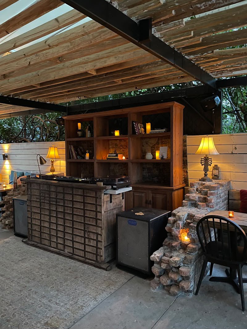 Outdoor DJ booth with turntables and loudspeakers under a covered patio