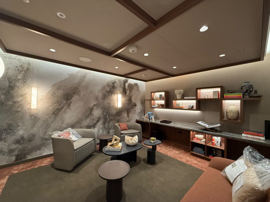 Private wealth client lounge with a mural wall, integrated lighting and technology concealed in the millwork