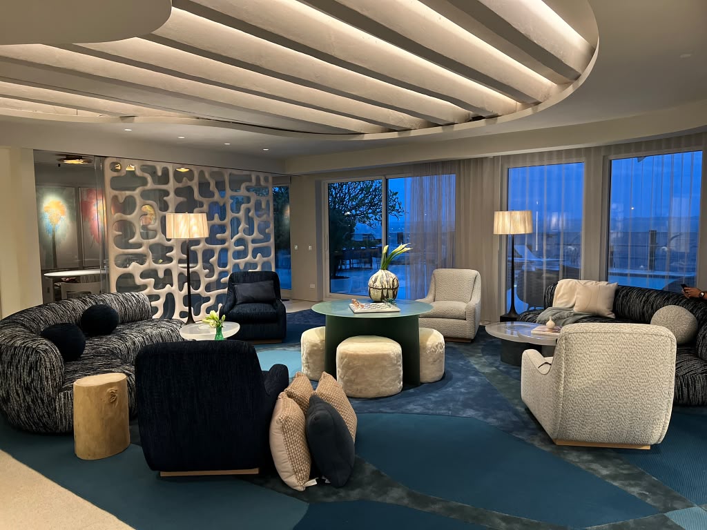 Residential lounge with a sculptural ceiling, decorative screen wall and an ocean view at dusk